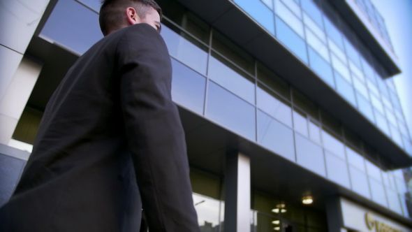 Attractive and Confident Businessman Walking near Modern Office Building