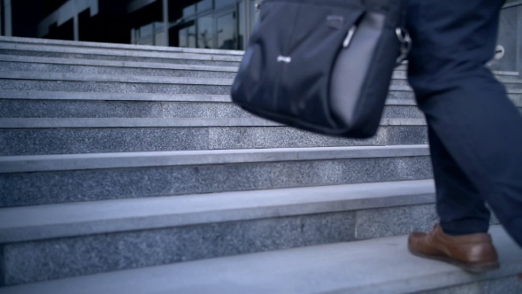 Young Stylish Businessman Walking Up the Stairs Towards Office Building