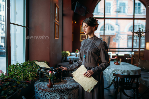 Serious dark hair lady stands near table - Stock Photo - Images