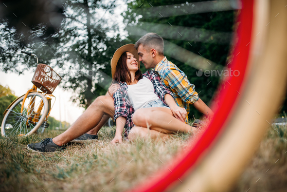 Love couple with vintage bikes sitting on grass - Stock Photo - Images