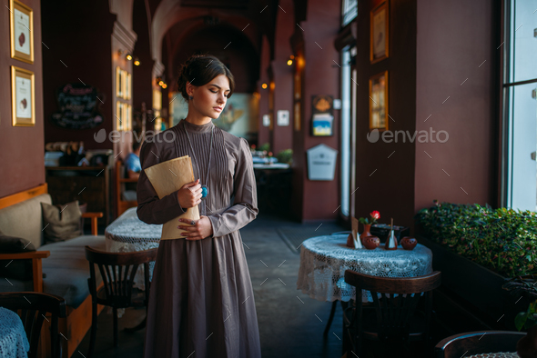 Young female person stands inside of cafe - Stock Photo - Images