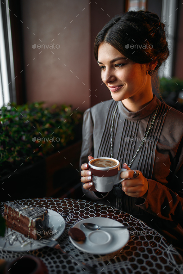A young girl with a cup of coffee in retro cafe - Stock Photo - Images