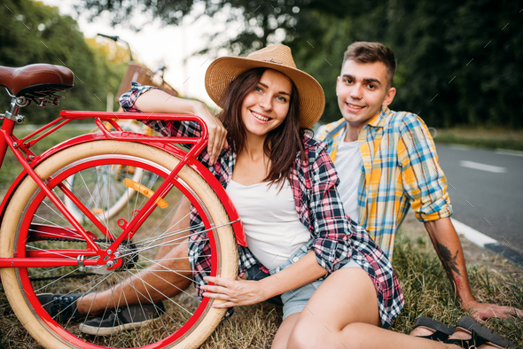 Love couple with vintage bikes sitting on roadside - Stock Photo - Images