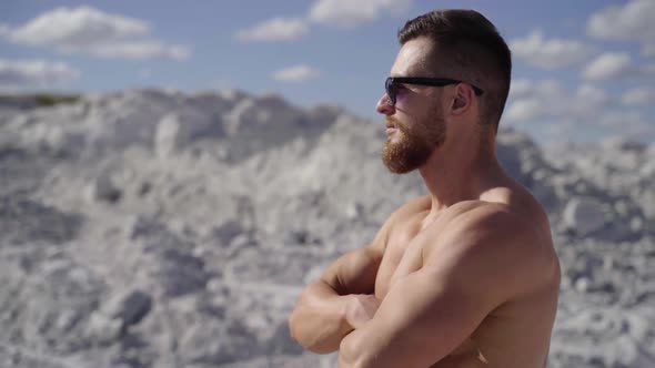 Strong man with naked torso standing on nature alt