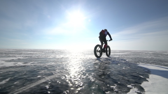 a Man Riding a Bicycle Across a Frozen Lake Baikal