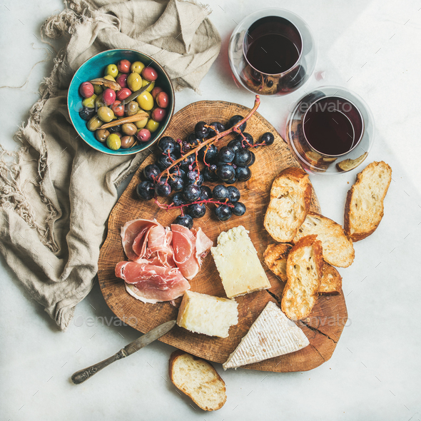 Variety of snacks and red wine in glasses, grey background - Stock Photo - Images