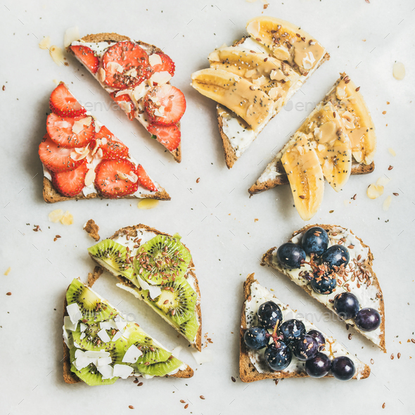 Healthy toasts with cream-cheese, fruit, nuts and seeds, square crop - Stock Photo - Images