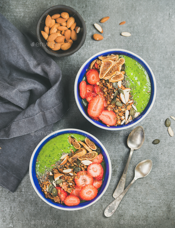 Healthy green smoothie breakfast bowls with granola, fruit, seeds, almonds - Stock Photo - Images