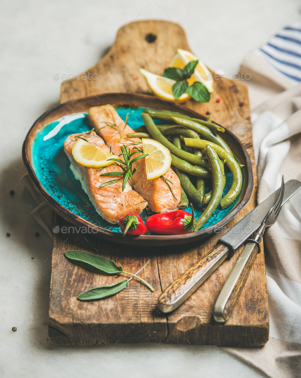 Roasted salmon fish with lemon, rosemary, chilli pepper and beans - Stock Photo - Images
