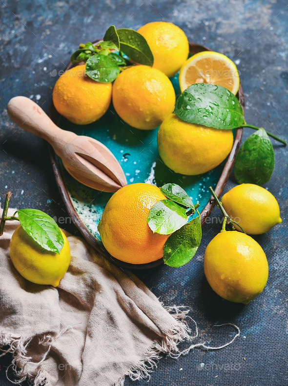 Freshly picked lemons with wet leaves in blue ceramic plate - Stock Photo - Images