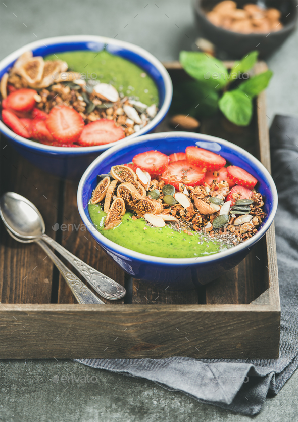 Green smoothie bowls with seeds, nuts, fruit and fresh berries - Stock Photo - Images
