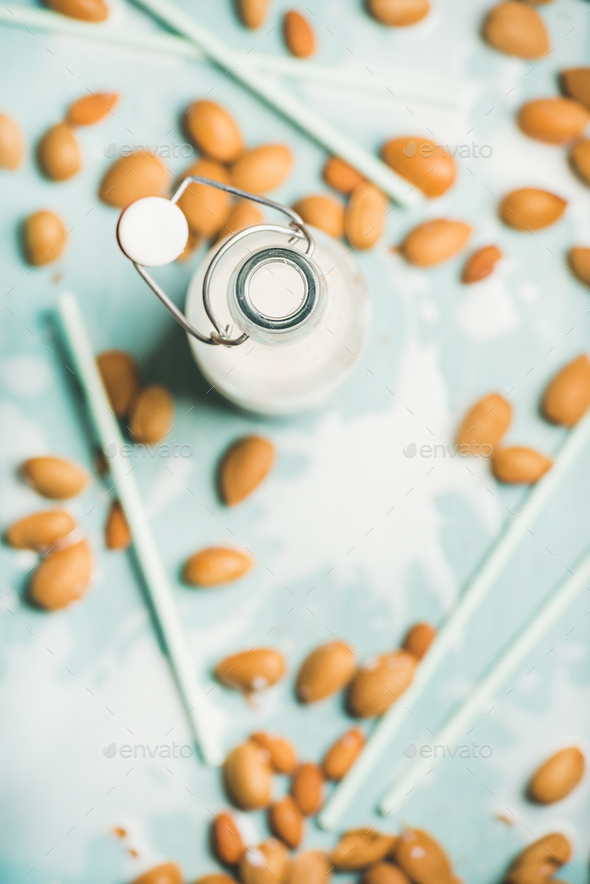 Almond milk in glass bottle over blue background, top view - Stock Photo - Images