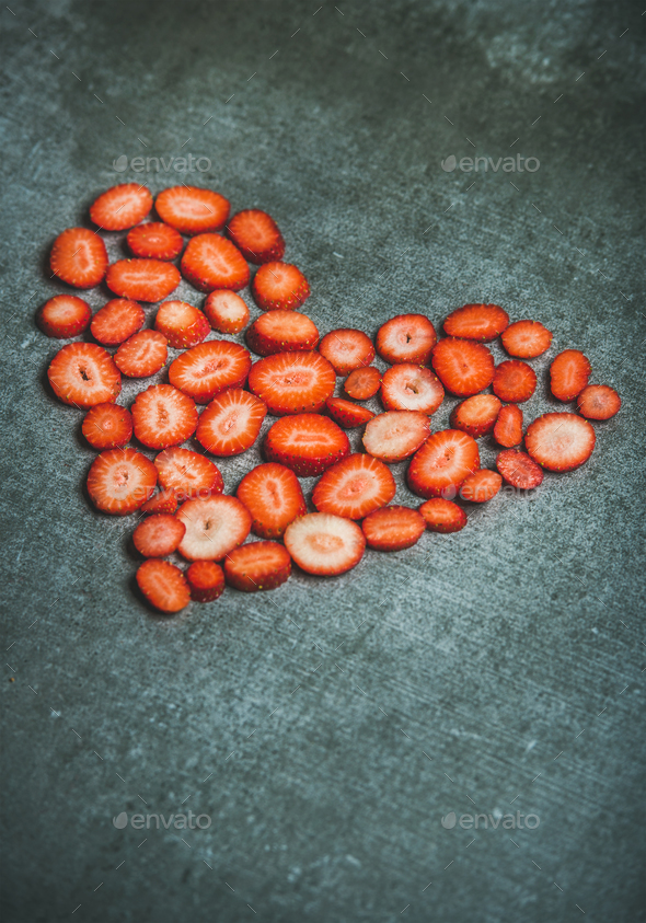 Heart shaped pieces of strawberries over grey background, copy space - Stock Photo - Images