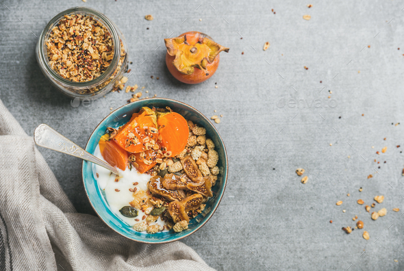 Oatmeal, quinoa gluten-free granola, yogurt, dried fruit, seeds, honey, persimmon - Stock Photo - Images