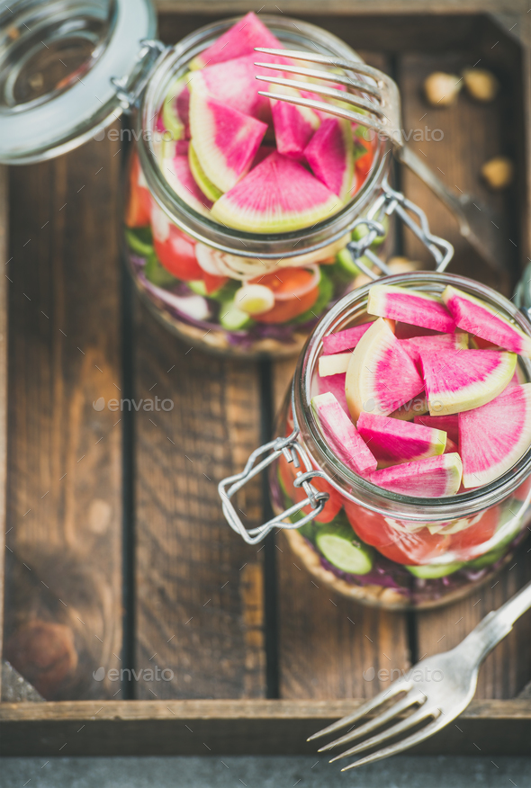 Healthy vegetarian salad in jars over wooden tray background - Stock Photo - Images
