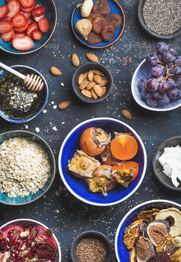 Ingredients in bowls for healthy breakfast over dark blue background - Stock Photo - Images