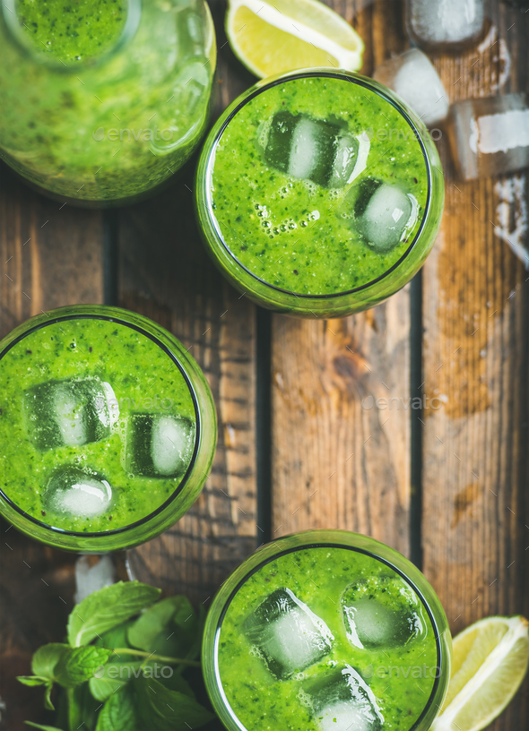 Fresh green smoothie with ice cubes in rustic wooden tray - Stock Photo - Images