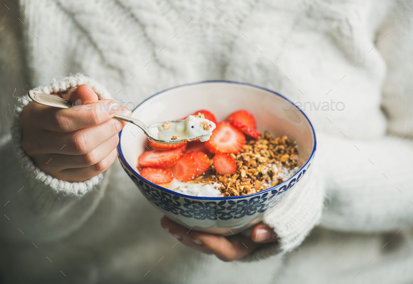 Healthy breakfast yogurt, granola, strawberry bowl in woman's hands - Stock Photo - Images