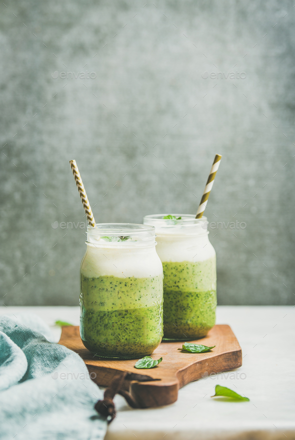 Ombre layered green smoothies with mint in jars with straws - Stock Photo - Images