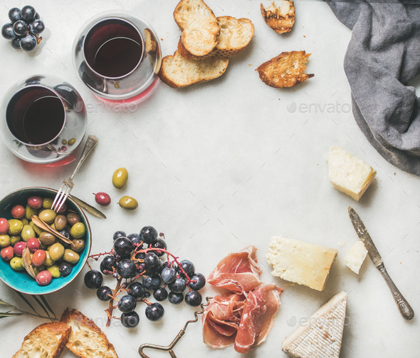 Cheese, olives, grapes, prosciutto, grilled baguette and red wine - Stock Photo - Images