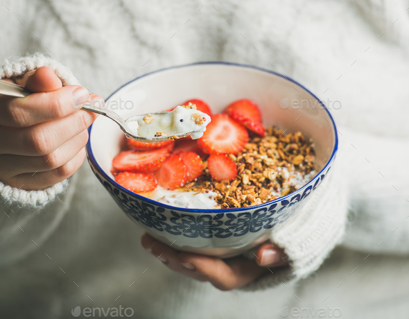 Healthy breakfast yogurt, granola, strawberry bowl in woman's hands - Stock Photo - Images