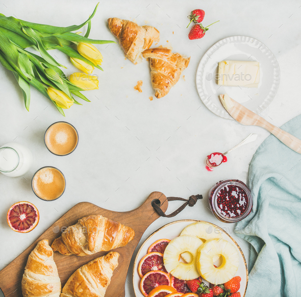Breakfast table with coffee, milk, pasrties, jam and yellow tulips - Stock Photo - Images