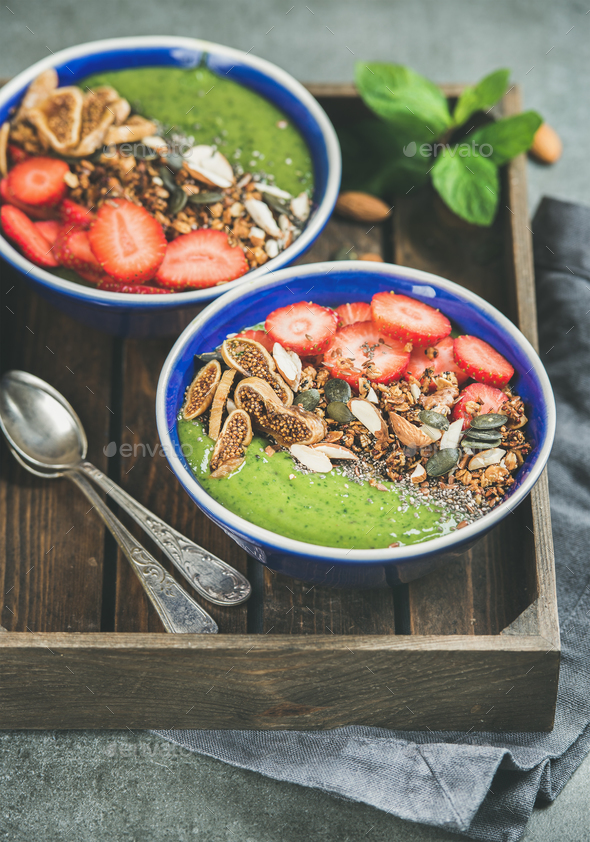 Green smoothie breakfast bowls with seeds, nuts, fruit and berries - Stock Photo - Images