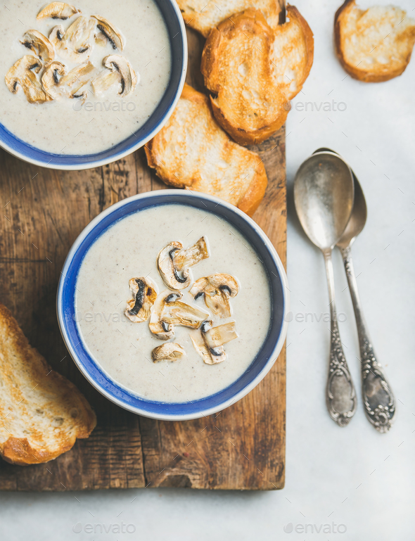 Close-up of creamy mushroom soup in bowls with grilled bread - Stock Photo - Images