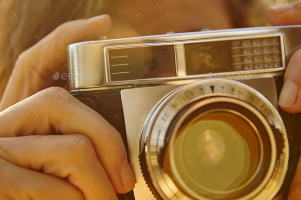 Woman taking pictures with vintage camera. Travel background. Fall season