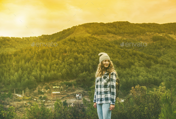 Young woman traveler in chekered shirt hiking in the mountains - Stock Photo - Images