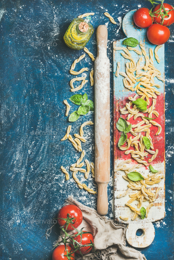 Fresh pasta casarecce, tomatoes, basil, olive oil on colorful board - Stock Photo - Images