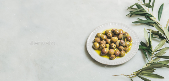 Pickled green Mediterranean olives and olive-tree branch, wide format - Stock Photo - Images
