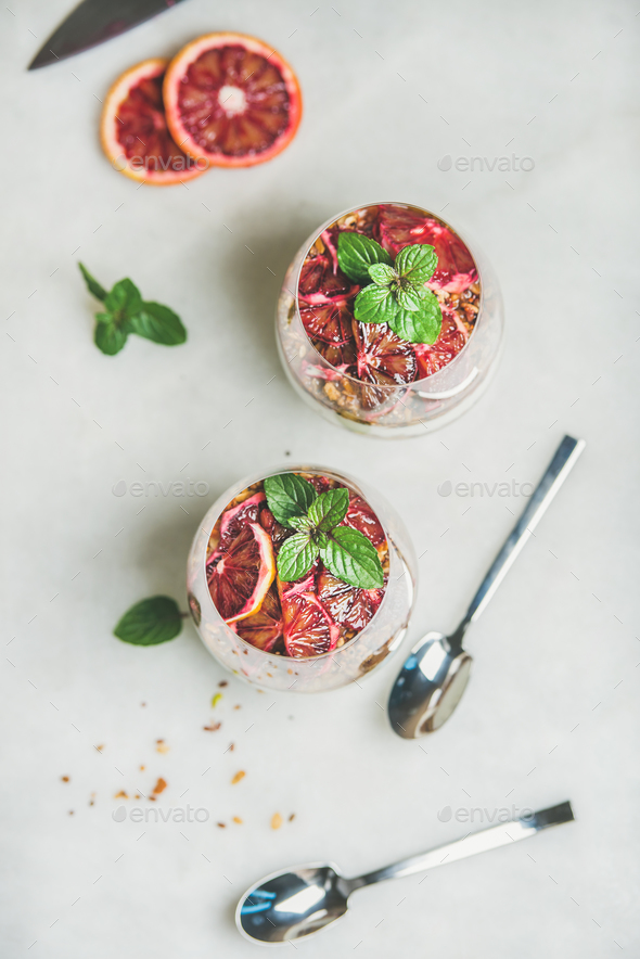 Healthy breakfast with yogurt, granola, orange layered parfait in glasses - Stock Photo - Images
