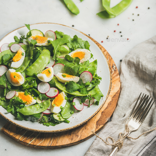 Green salad with radish, boiled egg, arugula, green pea, mint - Stock Photo - Images