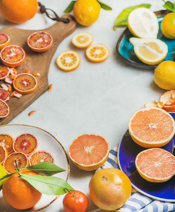 Natural fresh citrus fruits in ceramic plates over grey background - Stock Photo - Images