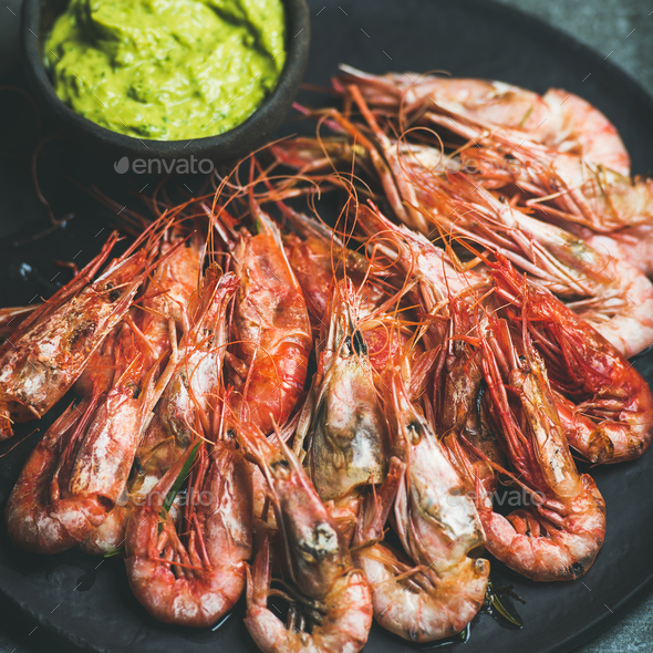 Roasted red shrimps with guacamole avocado sauce in black plate - Stock Photo - Images