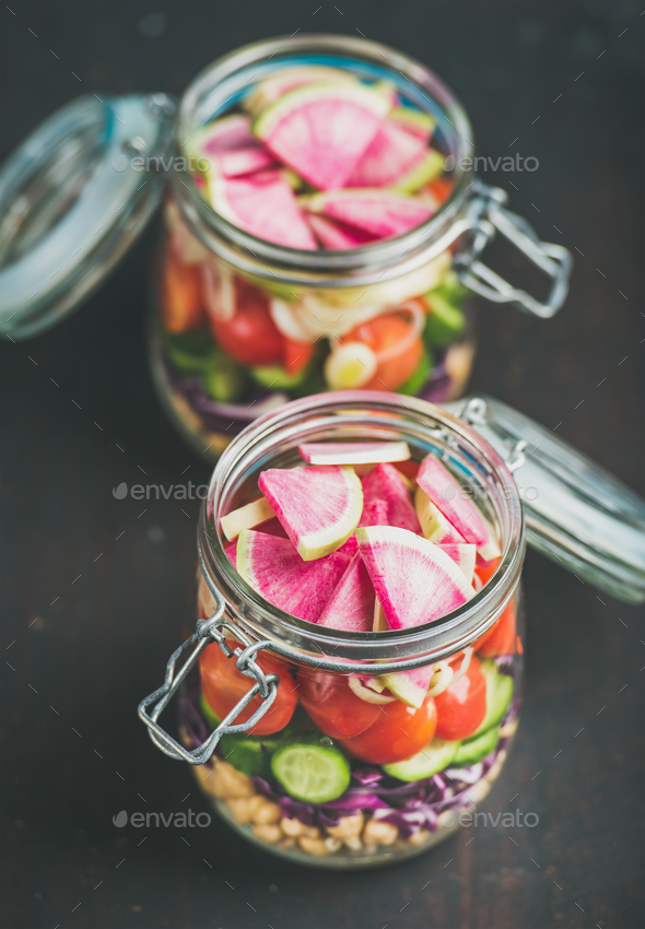 Vegetable, chickpea sprout salad in jars, dark scorched wooden background - Stock Photo - Images