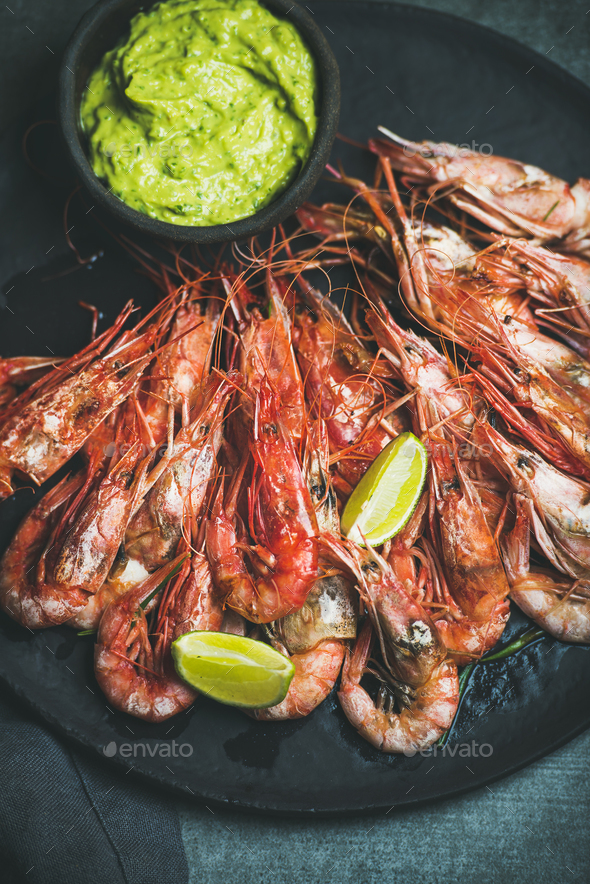 Roasted red shrimps with guacamole avocado sauce and lemon slices - Stock Photo - Images