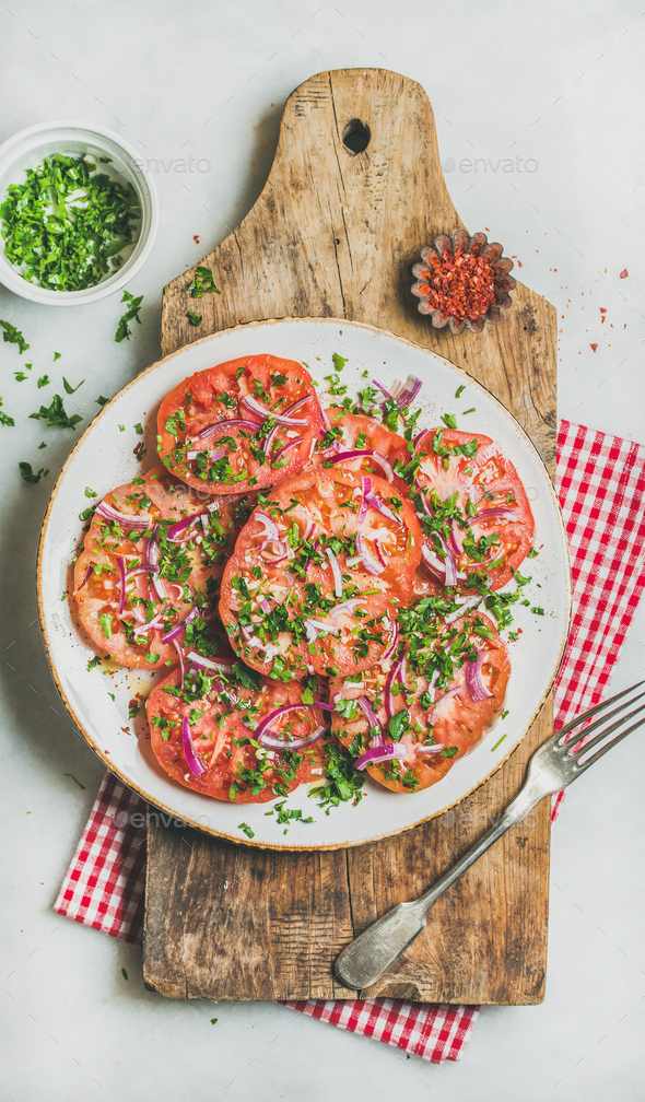 Fresh tomato, parsley and onion salad on shabby wooden board - Stock Photo - Images
