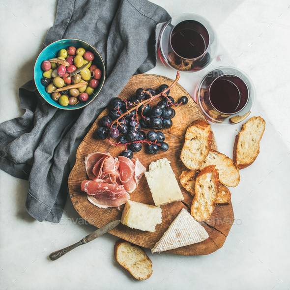 Red wine and snack set on board over marble background - Stock Photo - Images