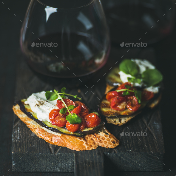 Wine, brushetta with eggplant, tomatoes, garlic, cream-cheese and arugula - Stock Photo - Images