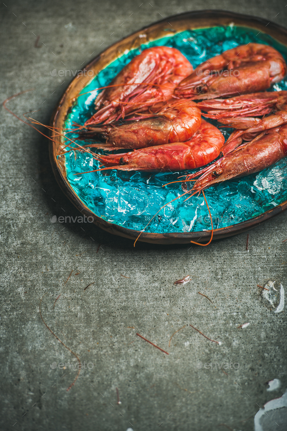 Raw uncooked red shrimps on ice in turquoise ceramic tray - Stock Photo - Images