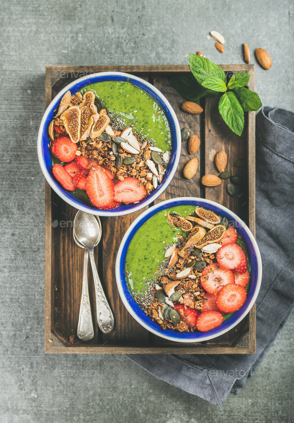 Healthy green smoothie breakfast bowls with granola, fruit, seeds - Stock Photo - Images