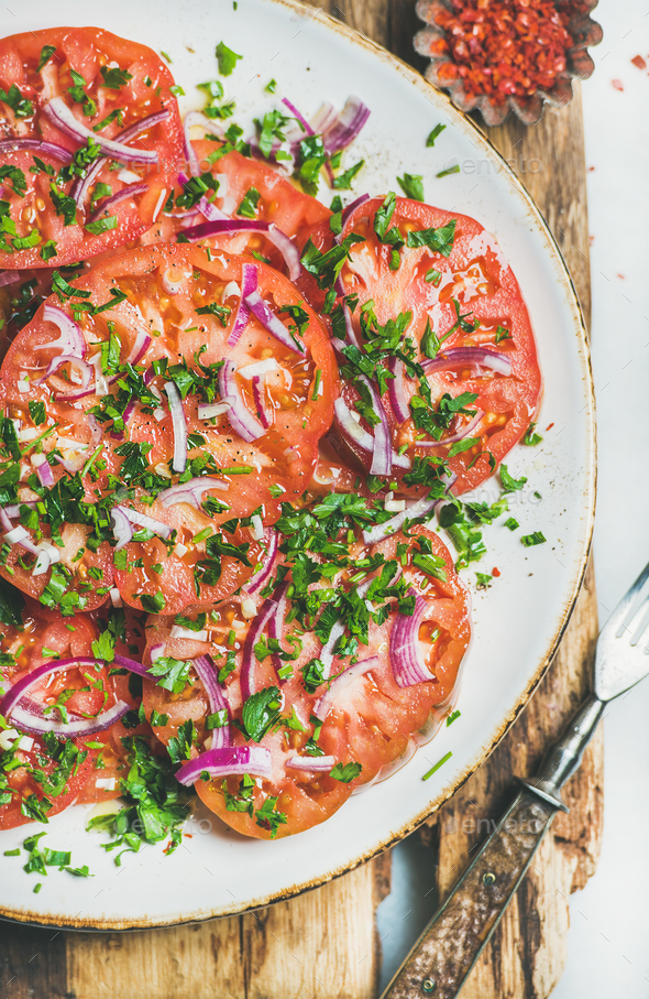 Fresh heirloom tomato, parsley and onion salad in plate - Stock Photo - Images