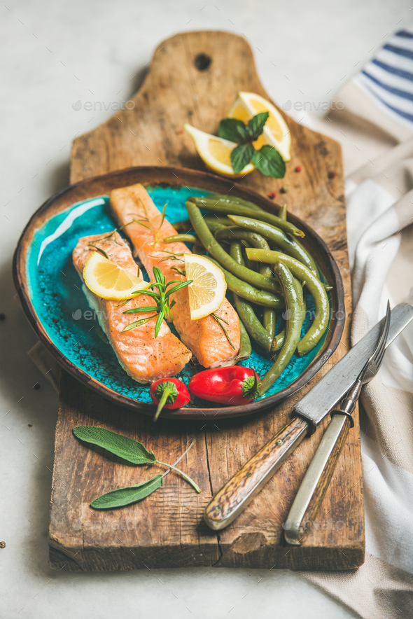 Roasted salmon fish with lemon, rosemary, chilli pepper, poached beans - Stock Photo - Images