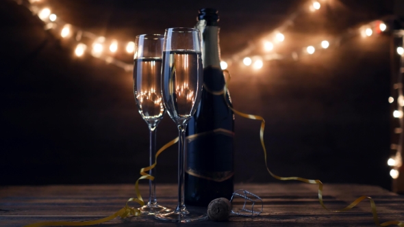 Two Flutes with Sparkling Wine Over Holiday Bokeh Blinking Background