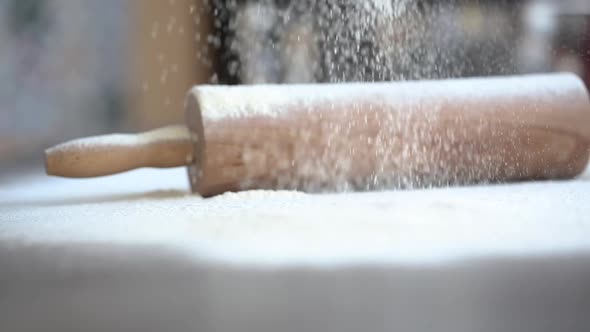 Flour pours on the table against the background 