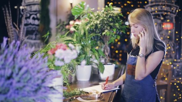 Female Florist on the Phone Orders Flowers From the Supplier alt