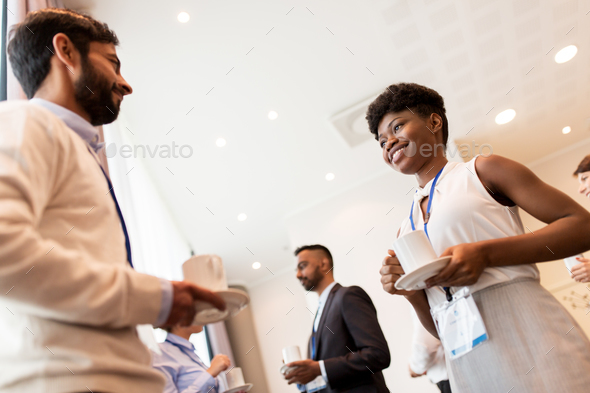 business people with conference badges and coffee - Stock Photo - Images