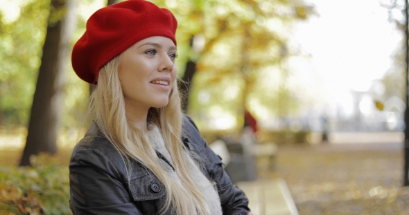 Woman in Red Beret Relaxing on Bench alt